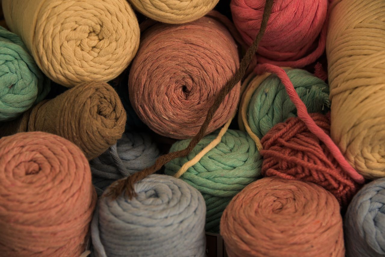 A variety of colorful yarn balls stacked together, perfect for knitting and crochet enthusiasts.