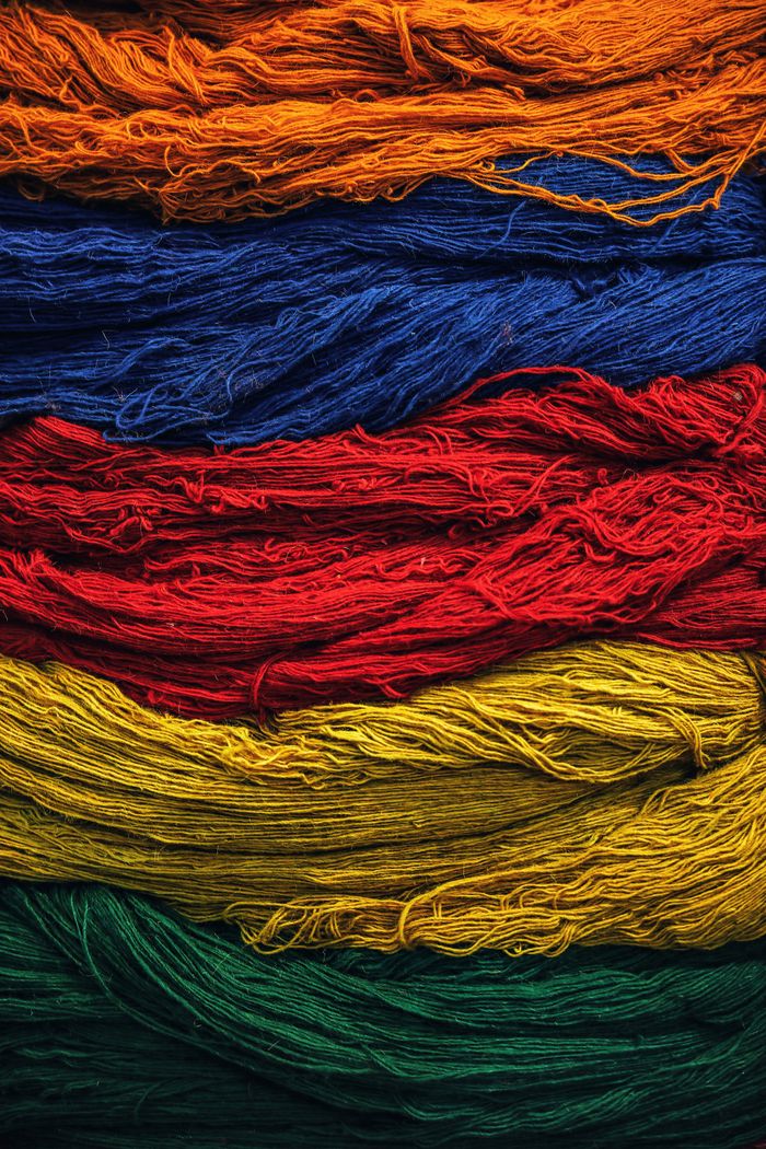 Bright multicolored textile threads arranged in layers, showcasing vivid colors and texture.